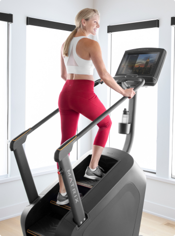 
                        
                         Woman using a Climbmill in a bright room with large windows
                        
                        