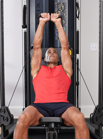 
                        
                         Person exercising on a weight machine in a home setting
                        
                        